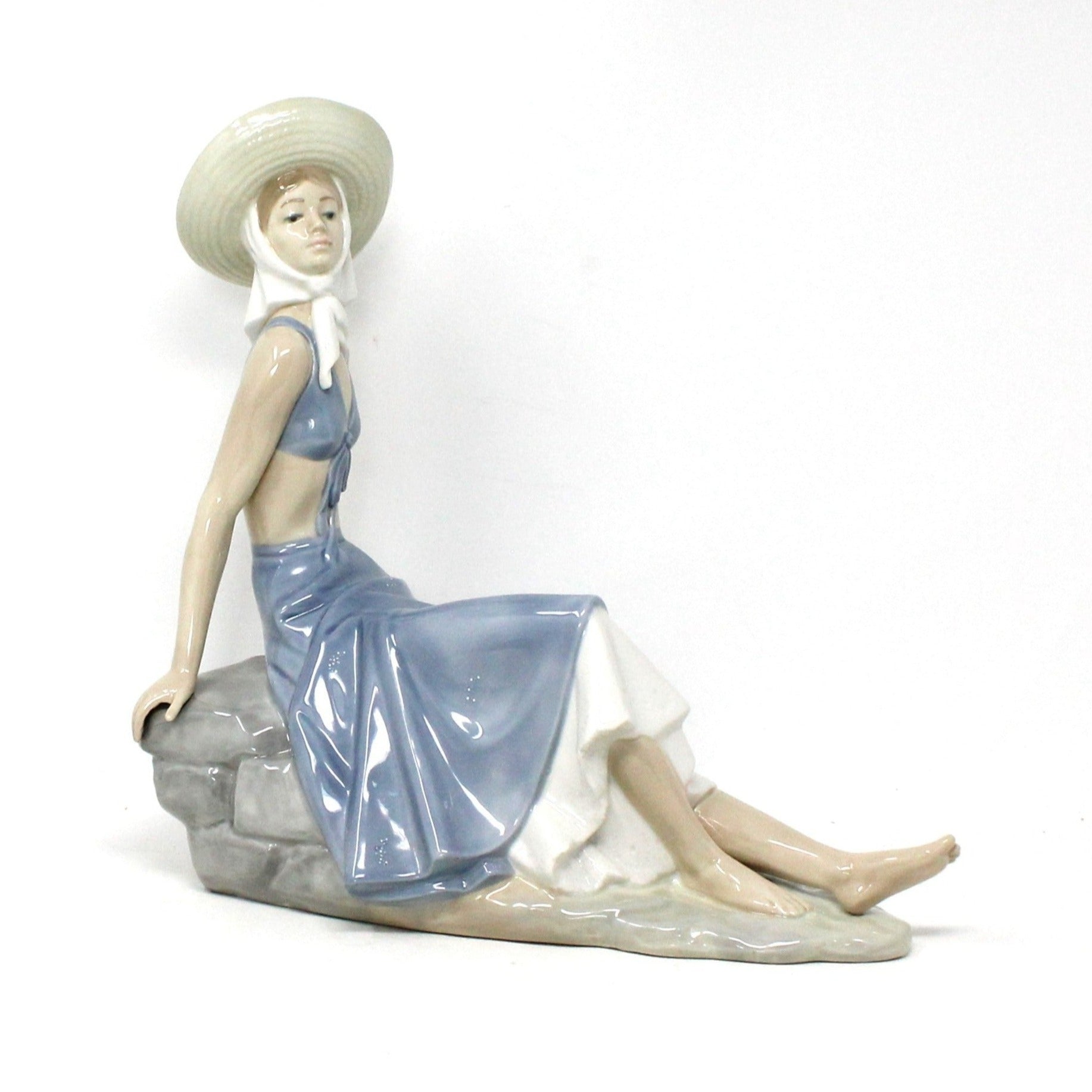 Sculpture, Nao / Lladro, Lady in Sunhat Sitting on Rock Wall
